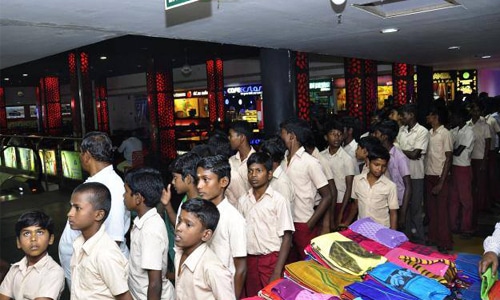 School students standing in an organized queue inside a shopping mall during an educational visit or CSR program