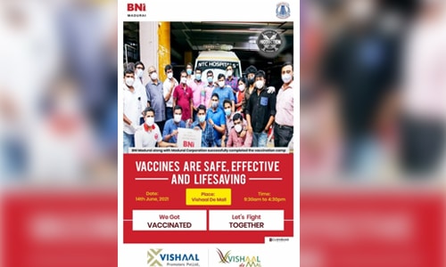 Group photo of staff and community members holding a COVID-19 vaccination awareness poster promoting safe and lifesaving vaccines